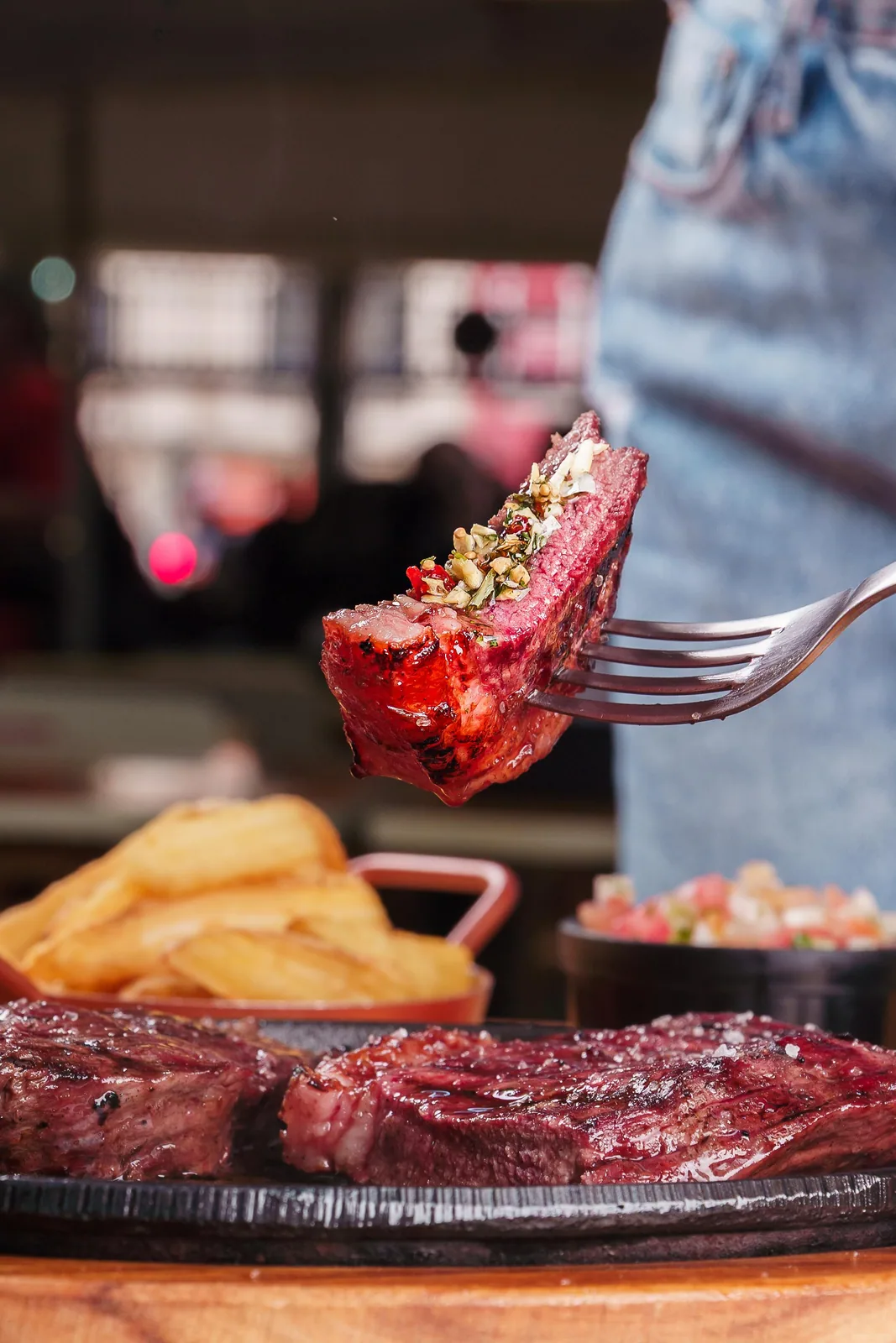 Pedaço de picanha grelhada com chimichurri no garfo